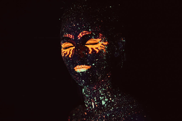 Porträt eines Mädchens in fluoreszierendem Puder gemalt. Halloween-Konzept. - Foto, Bild