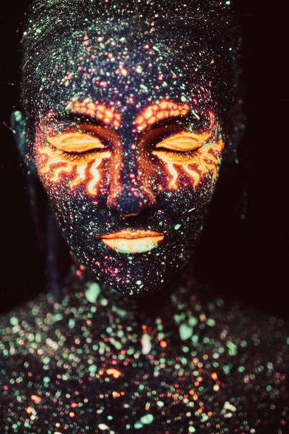 Ritratto di una ragazza dipinta in polvere fluorescente. Concetto Halloween
. - Foto, immagini