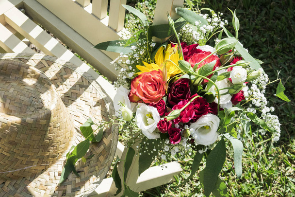 cappello rustico e mazzo di fiori nella scena del giardino rurale nella soleggiata giornata estiva
 - Foto, immagini