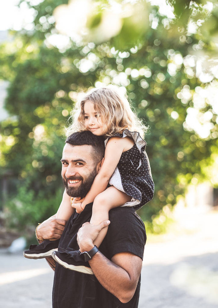 A little daughter sits on the shoulders - Photo, Image