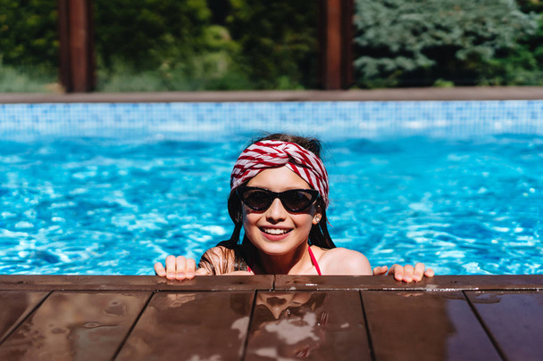 Nastolatek dziewczyna w basenie, patrząc na kamery - Zdjęcie, obraz