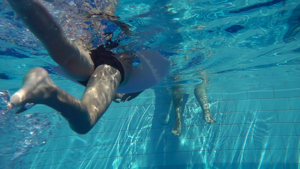 El niño nada en la piscina con un círculo inflable, cámara lenta
 - Imágenes, Vídeo