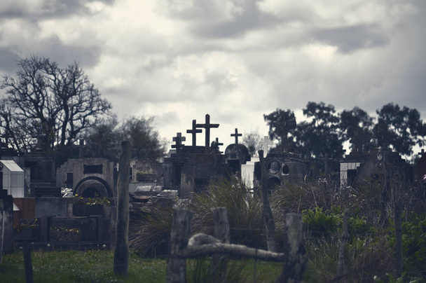 Grabsteine auf Friedhof gegen bewölkten Himmel - Foto, Bild