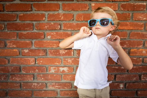 Sevimli Genç beyaz çocuk duvara karşı güneş gözlüğü takıyor. - Fotoğraf, Görsel