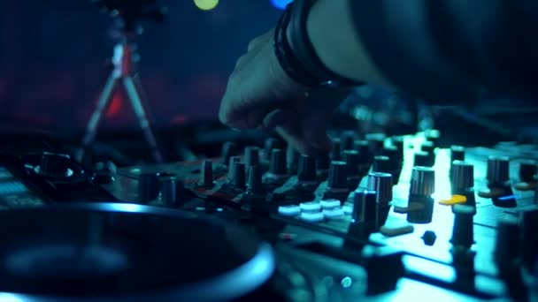 DJ mischt den Track im Nachtclub bei der Party auf. Kopfhörer im Vordergrund und DJ-Hände in Bewegung. schwärmen. - Filmmaterial, Video