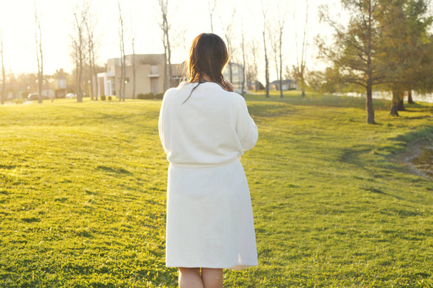 Woman wearing bathrobe walking outdoors at sunset - Foto, Imagem