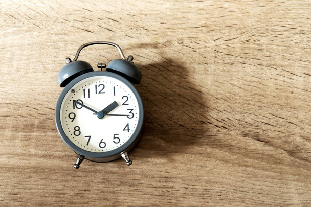 Kahverengi ahşap arka planda alarm saati, zaman yönetimi kavramı - Fotoğraf, Görsel