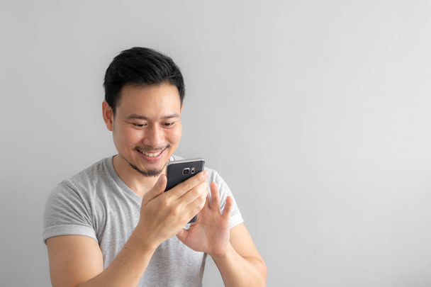 Smile and happy face of Asian man use and touch his smartphone. - Foto, Imagen