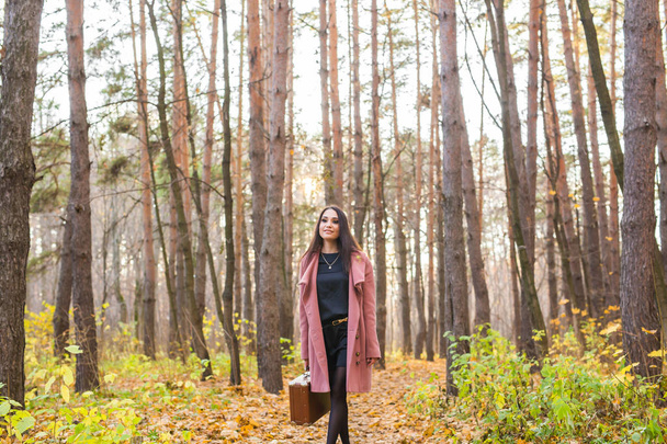 People, season and nature concept - Young woman walking in autumn park - Photo, Image