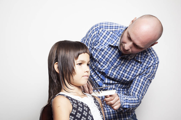 coiffeur coupe les cheveux de la petite fille dans le salon de beauté, gros plan
  - Photo, image
