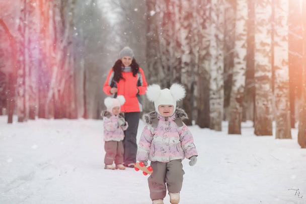 Los niños caminan en el parque en invierno. Bosque de invierno una familia con
 - Foto, imagen
