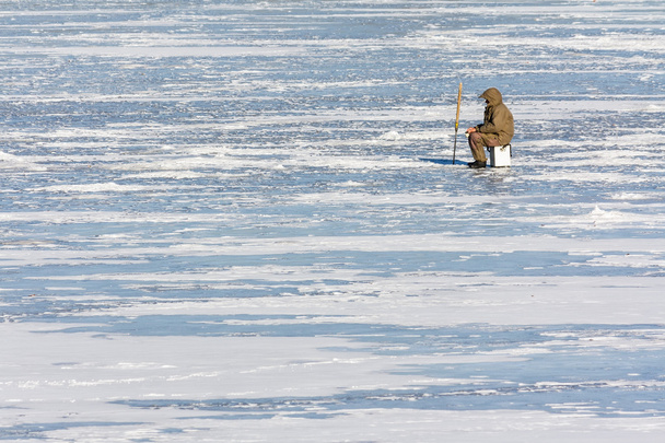 Fisherman on ice in winter - Фото, изображение