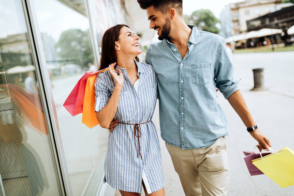 Happy attractive loving couple enjoy spending time in shopping together - Фото, изображение