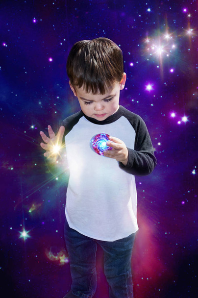 Enfant garçon cosmique tenant la planète en main dans l'espace fantaisie
 - Photo, image