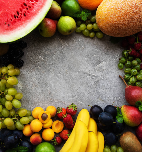 Fresh summer fruits and berries on a concrete background - Photo, Image