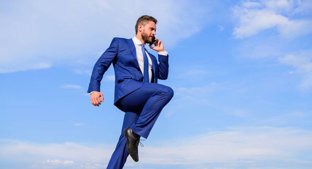 Businessman formal suit jump while call smartphone sky background. Entrepreneur in motion success expression. Businessman solving business problems on phone. Keep going towards your goal. Never stop - Foto, imagen