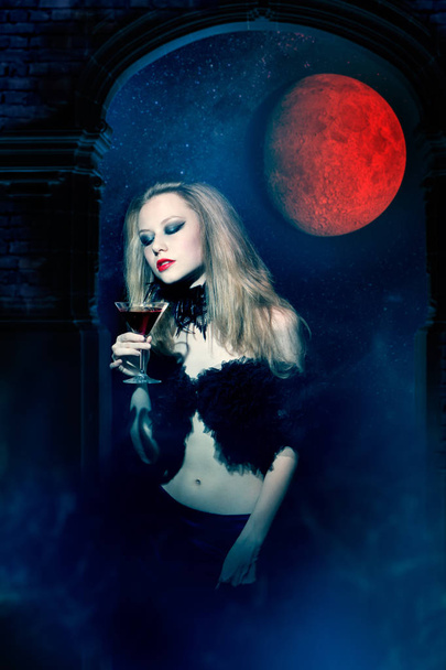 Aggressive vampire woman with glass of wine - Fotó, kép