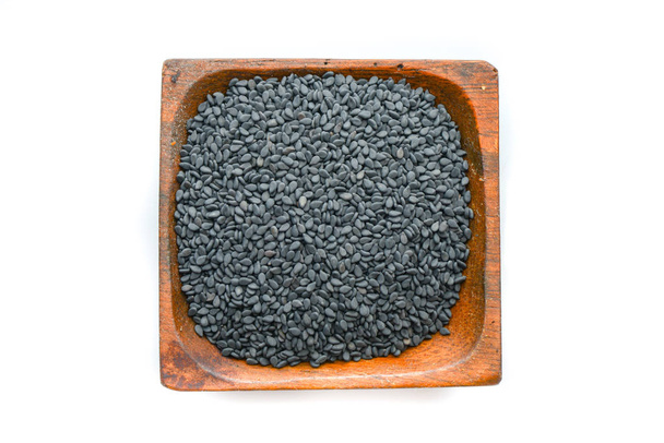 Semillas de sésamo negro en un plato de madera
 - Foto, imagen