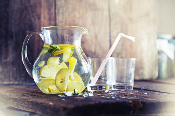 Glasses and jar of lemonade on wooden table - Zdjęcie, obraz