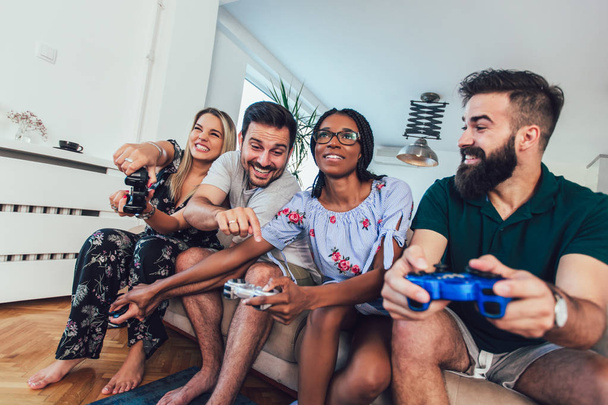 Группа друзей вместе играют в видеоигры
. - Фото, изображение