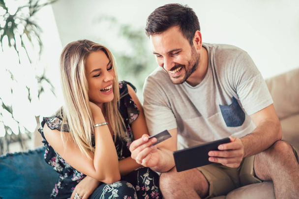Uśmiechający się zadowolony para para z komputera typu tablet pc i kredytowych karty w domu Technologia, online zakupy i ludzie concept  - Zdjęcie, obraz