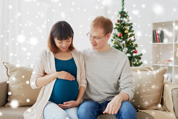 pregnant wife with husband at home at christmas - Foto, Imagen