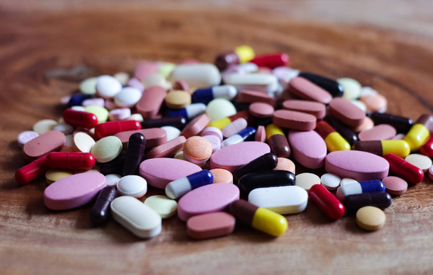 pila de pastillas para medicamentos tabletas cápsulas en fondo de madera
 - Foto, Imagen