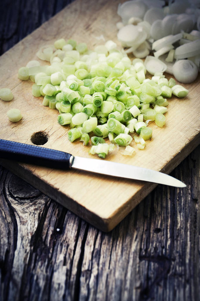 Green onion with chalkboard and knife on wooden background - Фото, зображення