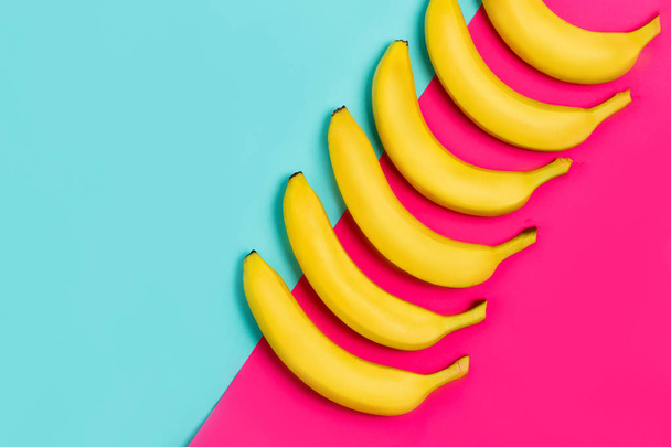 Ripe yellow bananas on a paper colorful background with copy space. From top view - 写真・画像