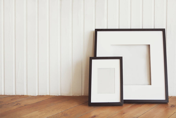 Dva plakáty na dřevěné podlaze u bílé stěny s kopírovacím prostorem - Fotografie, Obrázek