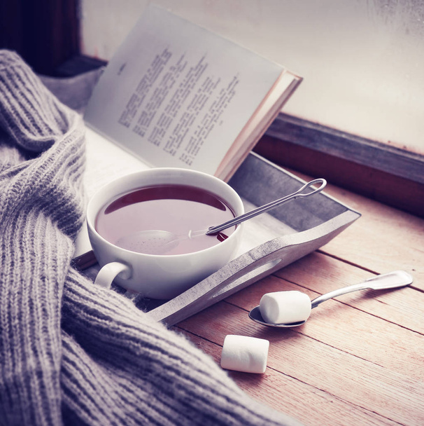 cup of hot tea and book on wooden surface - Valokuva, kuva