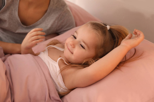 Cute little girl lying in bed at home - Foto, Imagen