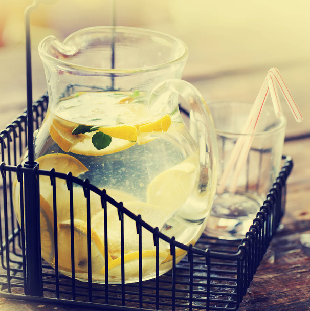 Pot of lemonade with ice on wooden table - Zdjęcie, obraz