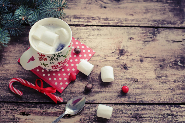 closeup view of coffee cup with marshmallows and christmas decorations over wooden table - Foto, afbeelding
