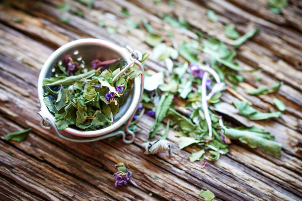 closeup view of dry tea herbs over wooden background - Zdjęcie, obraz