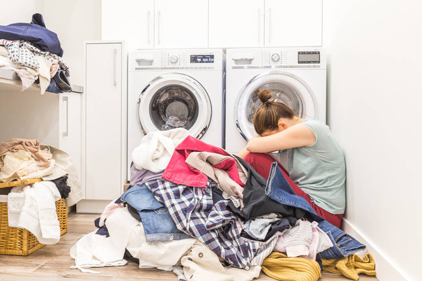 Mujer triste sentada en una lavandería
 - Foto, imagen