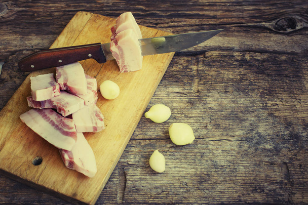 slices of meat with knife on wooden background - Fotoğraf, Görsel