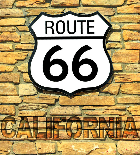 Ηνωμένες Πολιτείες ιστορική διαδρομή 66 πινακίδα της Καλιφόρνια σε έναν τοίχο από τούβλα. Αμερικανικό αυτοκινητόδρομο από την πόλη του Σικάγο του Ιλλινόις στην πόλη Σάντα Μόνικα της Καλιφόρνια. - Φωτογραφία, εικόνα