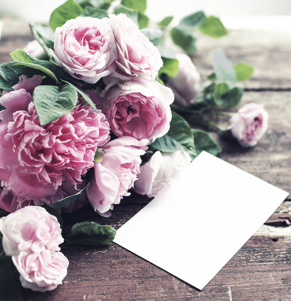 Καταπληκτικά λουλούδια ροζ με λευκό χαρτί για αντίγραφο χώρου σε φόντο ξύλινη - Φωτογραφία, εικόνα
