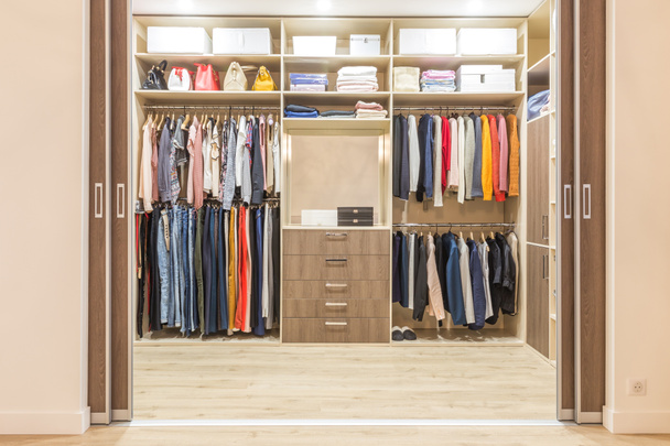 guarda-roupa de madeira moderna com roupas penduradas no trilho em andar no armário design interior
 - Foto, Imagem