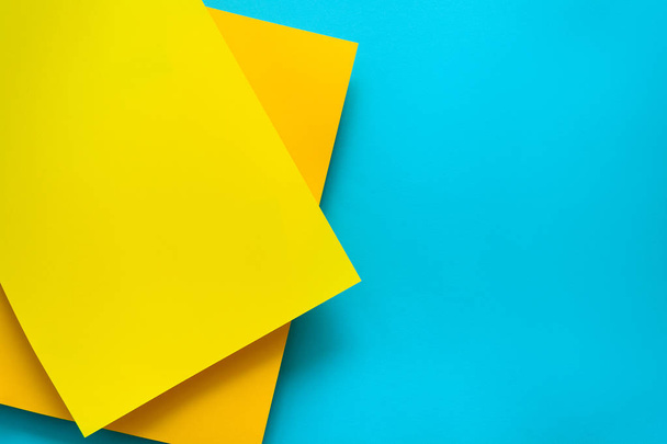 Blue and yellow pastel color papered background. Volume geometric flat lay. Top view. Copy space - Photo, Image