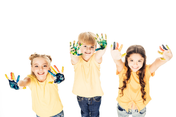 mutlu çocuklar boya ve kameraya gülümseyen eller gösterilen yüksek açı bakış beyaz izole - Fotoğraf, Görsel