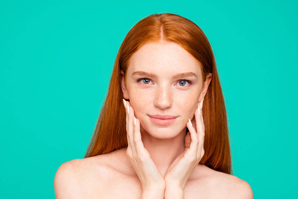 Health and beauty concept. Close-up portrait of nice cute attractive red-haired girl with shiny pure fresh clean skin, touching face, spa, therapy, treatment, isolated over green turquoise background - Fotografie, Obrázek
