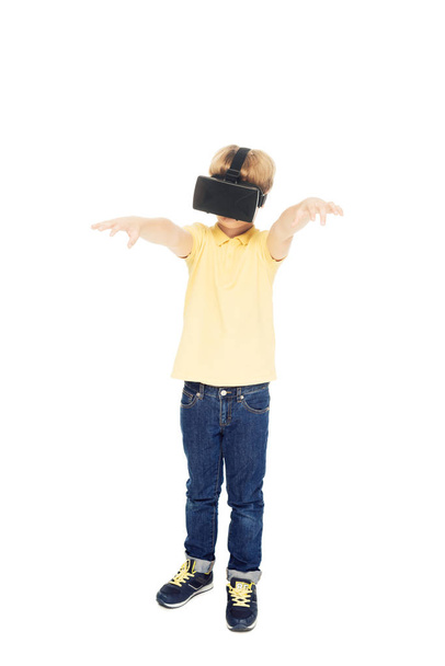 full length view of cute little boy using virtual reality headset isolated on white - Foto, afbeelding