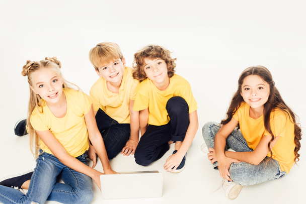 high angle view of adorable kids using laptop and smiling at camera isolated on white - Photo, Image