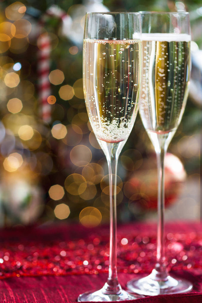 Deux flûtes à champagne sur fond de Noël avec arbre de Noël
 - Photo, image