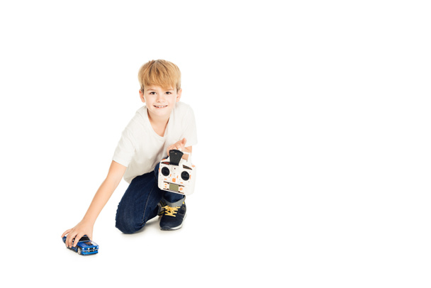 adorable boy playing with radio controlled car isolated on white and looking at camera - Valokuva, kuva