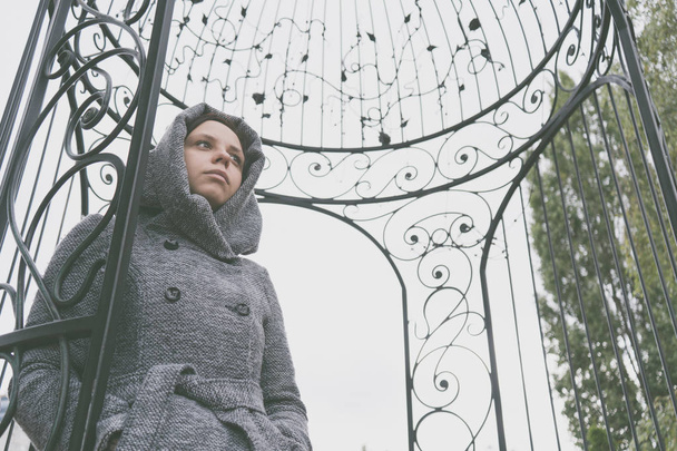 Girl in a coat posing outside in the autumn in gloomy weather, peering thoughtfully into the distance. the concept of autumn depre - Photo, Image