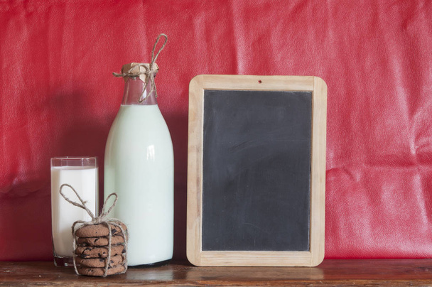 Schokoladenkekse, Glasbecher Milch auf rustikalem Holz Hintergrund mit Kopierraum leere Tafel - Foto, Bild