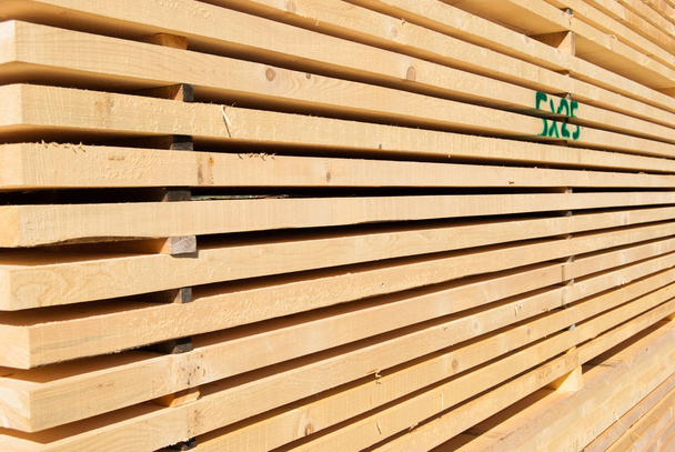 Planks of raw wood neatly arranged in the open air for drying - 写真・画像